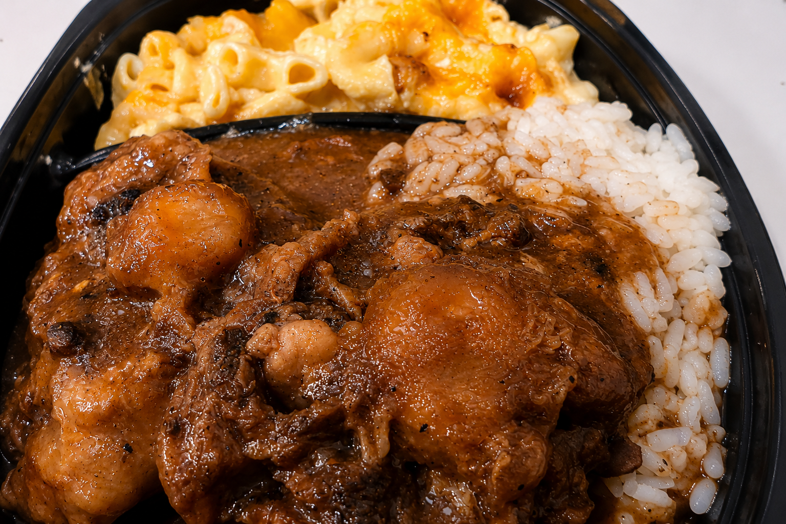 Sistah's signature soul food plate with rich gravy over white rice and baked macaroni and cheese