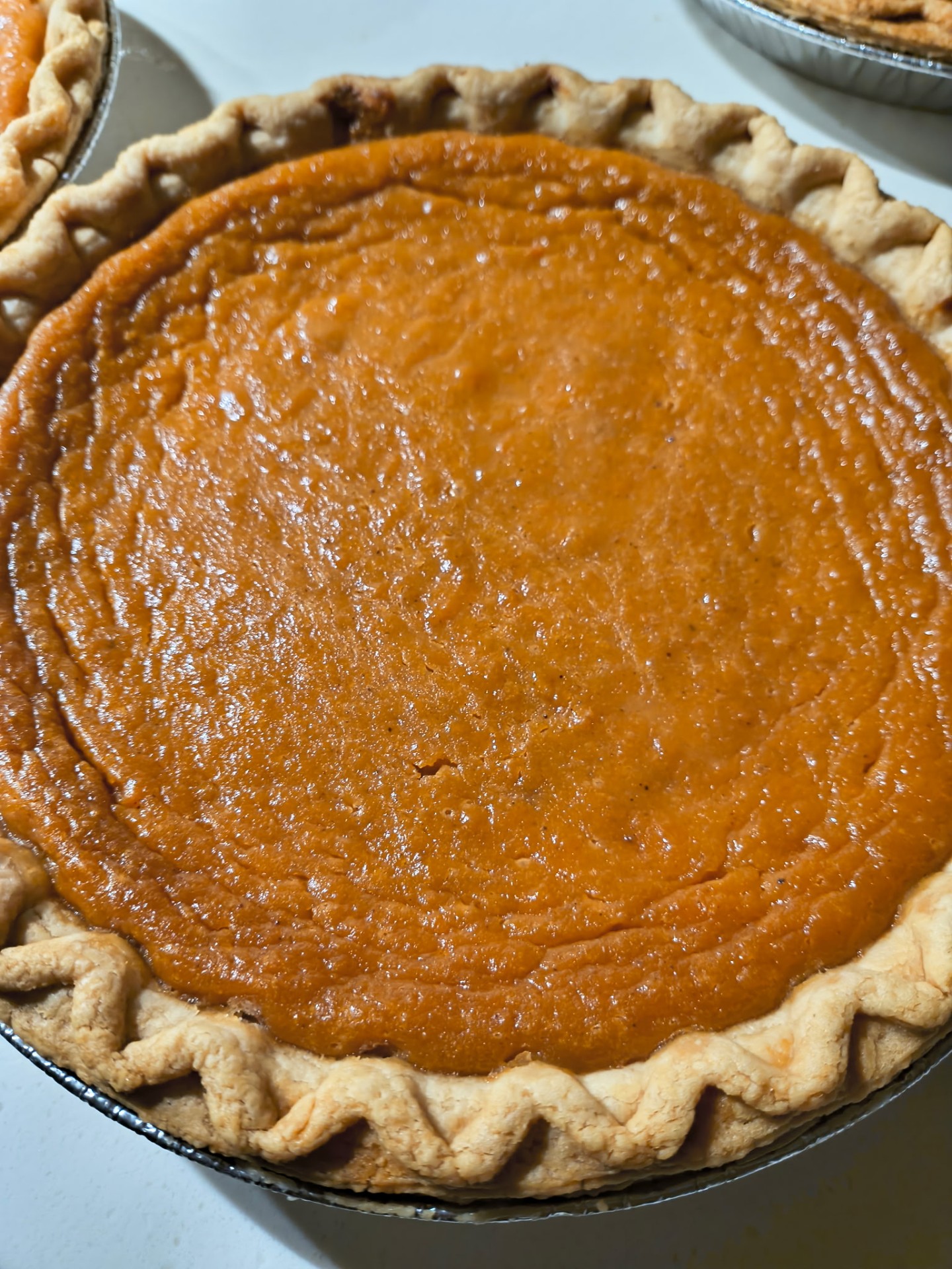 Golden sweet potato pie cooling in a hand-crimped crust